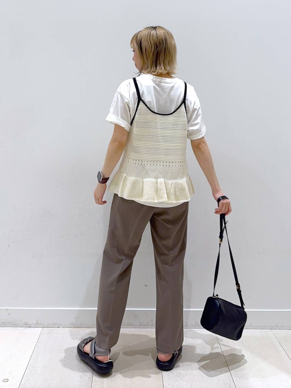 ブラウン系のその他パンツ、ホワイト系のTシャツ/カットソー、ブラック系のショルダーバッグを着用したレディースの春コーディネートの3枚目の写真