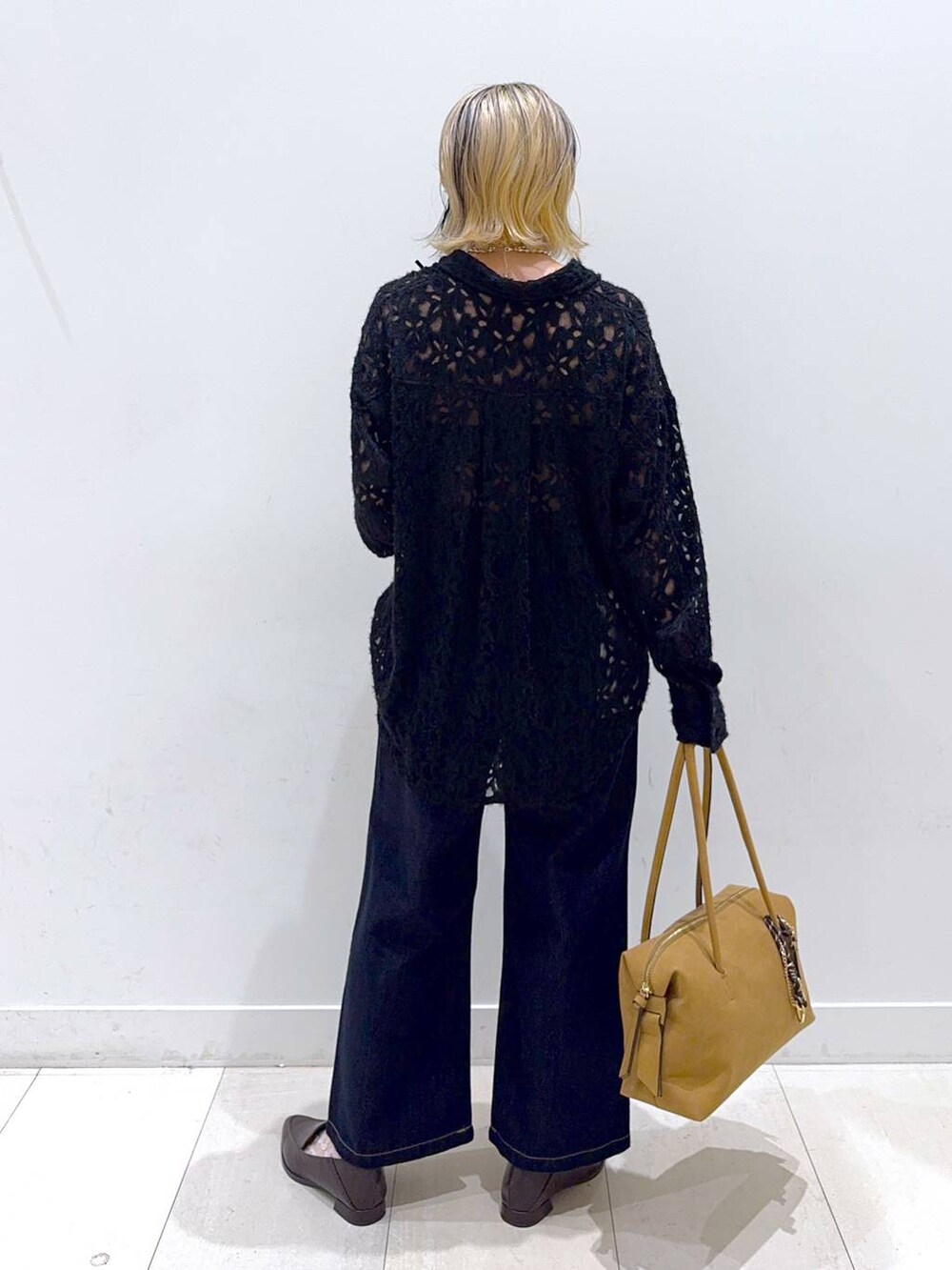 ベージュ系のボストンバッグ、ブルー系のデニムパンツ、ブラウン系のパンプスを着用したレディースの秋コーディネートの3枚目の写真