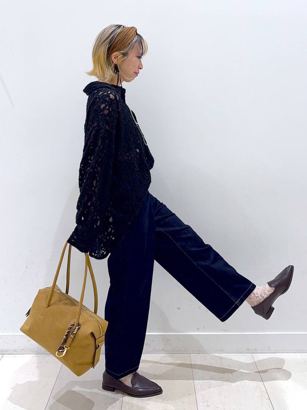 ベージュ系のボストンバッグ、ブルー系のデニムパンツ、ブラウン系のパンプスを着用したレディースの秋コーディネートの2枚目の写真