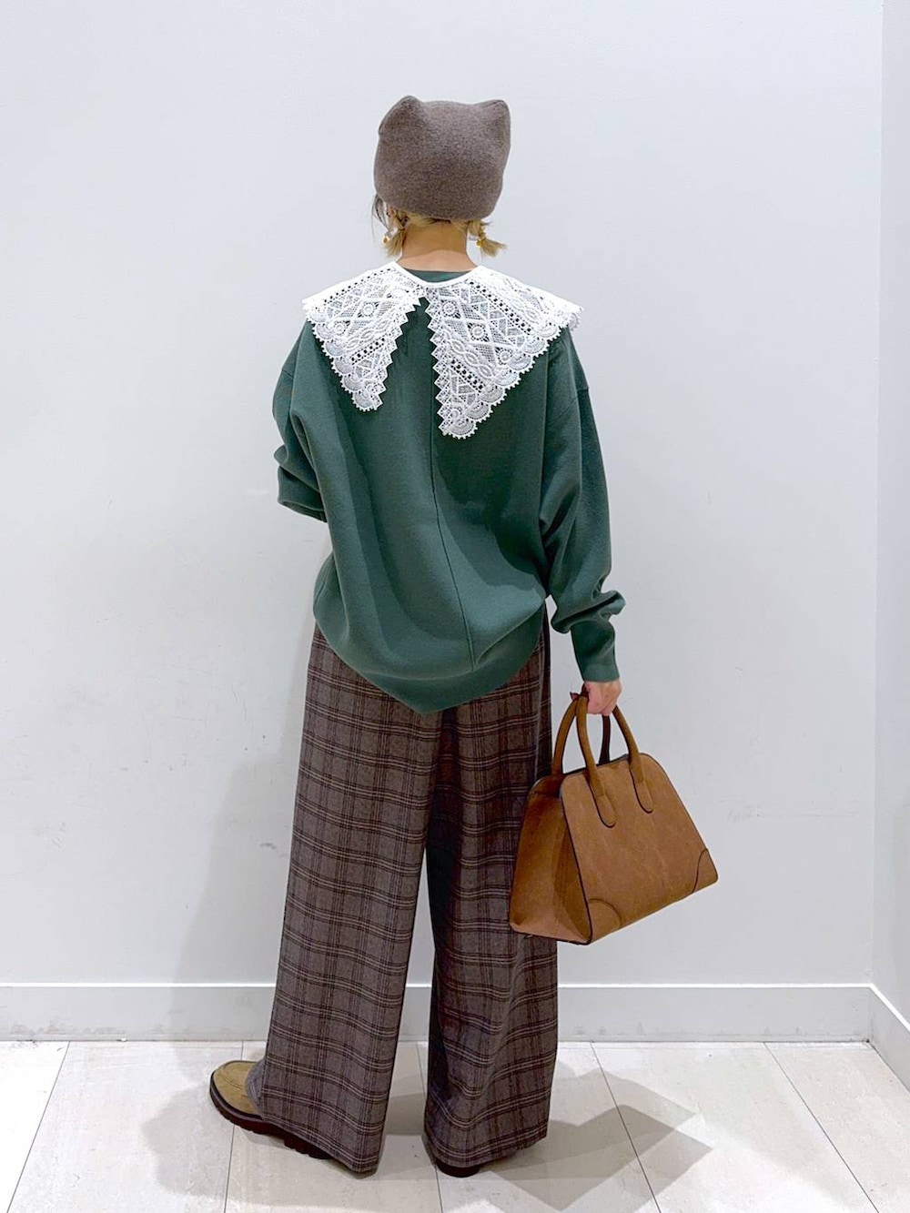 グリーン系のスウェット、ベージュ系のローファー、ベージュ系のショルダーバッグを着用したレディースの秋コーディネートの3枚目の写真