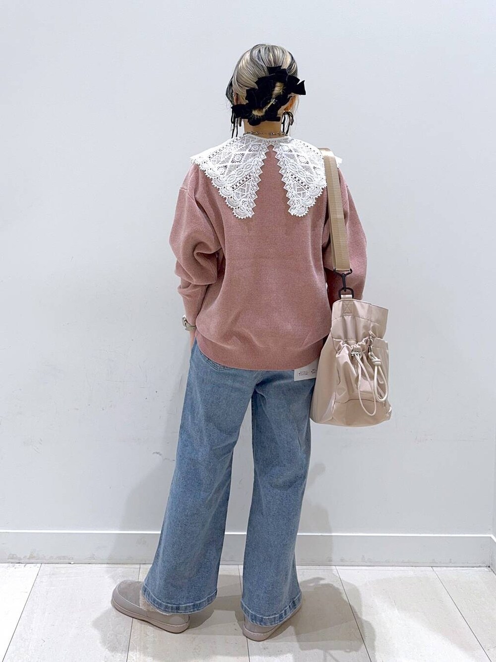 ベージュ系のショルダーバッグ、ブルー系のデニムパンツ、グレー系のその他シューズを着用したレディースの秋コーディネートの3枚目の写真