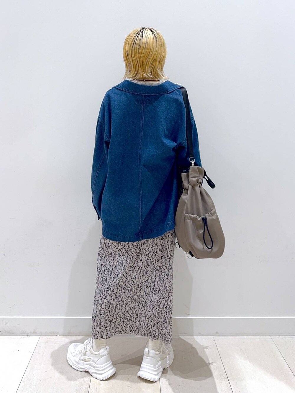 グレー系のバックパック/リュック、ホワイト系のスニーカー、ベージュ系のニット/セーターを着用したレディースの秋コーディネートの3枚目の写真