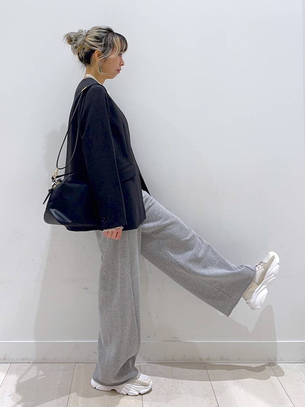 ブラック系のショルダーバッグ、ホワイト系のTシャツ/カットソー、グレー系のスウェットパンツを着用したレディースの冬コーディネートの2枚目の写真