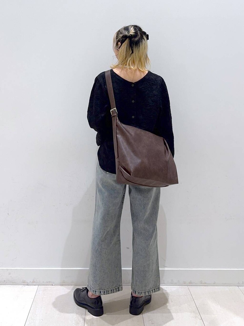 ブルー系のデニムパンツ、ブラック系のその他シューズ、ブラウン系のショルダーバッグを着用したレディースの冬コーディネートの3枚目の写真