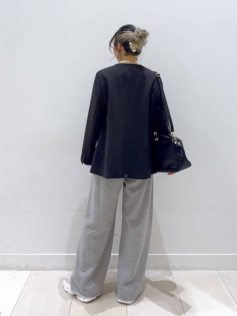 ブラック系のショルダーバッグ、ホワイト系のTシャツ/カットソー、グレー系のスウェットパンツを着用したレディースの冬コーディネートの3枚目の写真