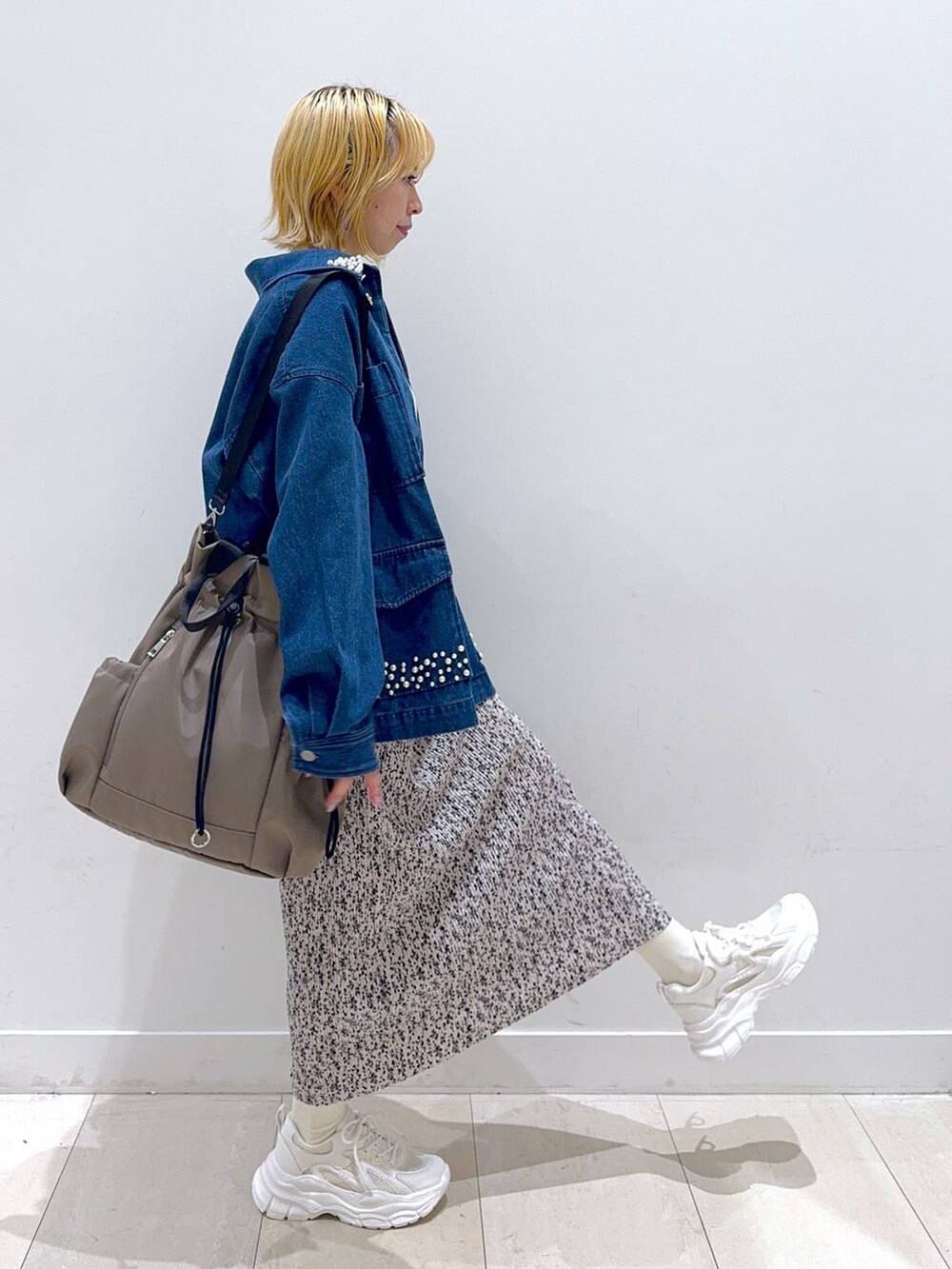 グレー系のバックパック/リュック、ホワイト系のスニーカー、ベージュ系のニット/セーターを着用したレディースの秋コーディネートの2枚目の写真