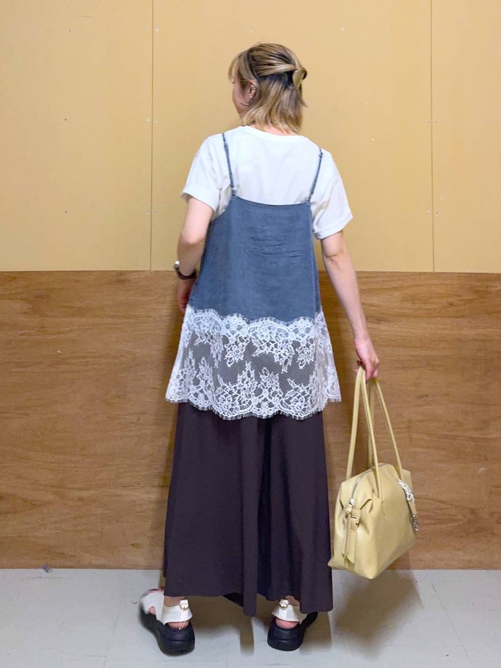イエロー系のボストンバッグ、ブラウン系のその他パンツ、ホワイト系のTシャツ/カットソーを着用したレディースの春コーディネートの3枚目の写真