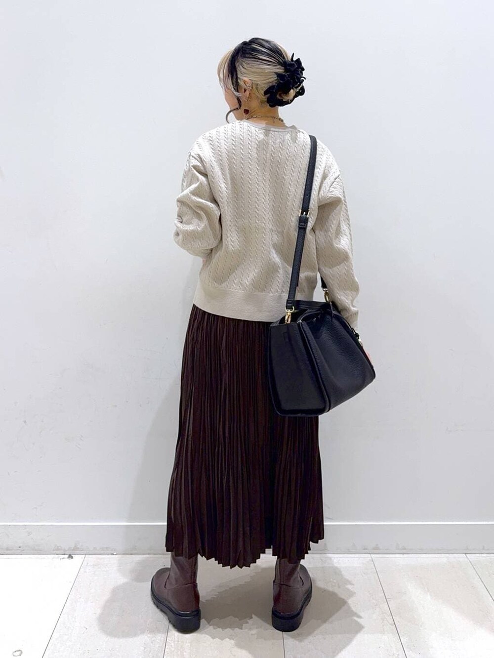 ブラック系のトートバッグ、ブラウン系のブーツ、ブラウン系のスカートを着用したレディースの冬コーディネートの3枚目の写真