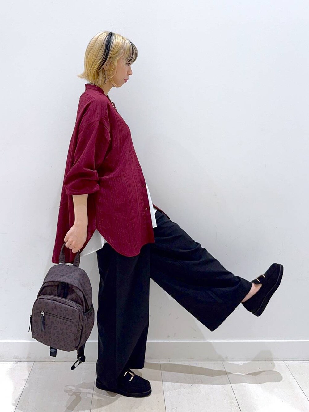 ブラウン系のバックパック/リュック、ブラック系のローファー、ブラック系のその他パンツを着用したレディースの秋コーディネートの2枚目の写真