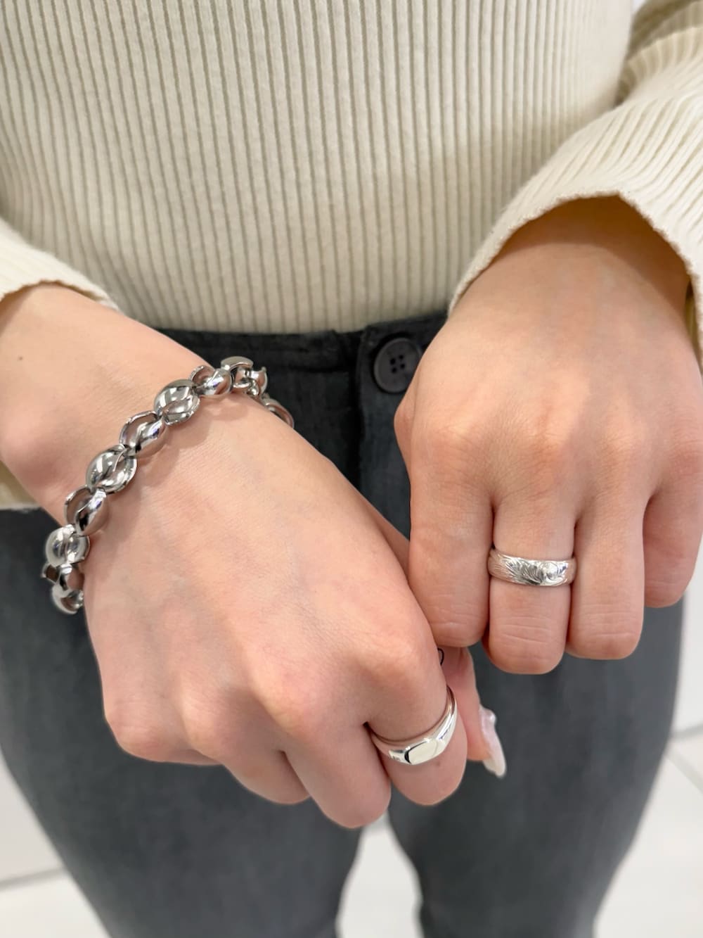 シルバー系のネックレス、その他のブレスレット、シルバー系のリングを着用したレディースの春コーディネートの2枚目の写真