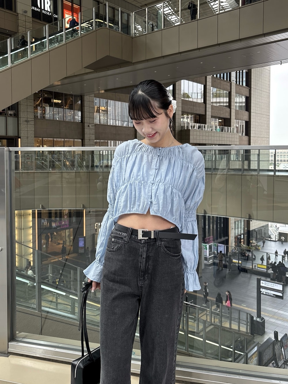 ブルー系のシャツ/ブラウス、ブラック系のデニムパンツを着用したレディースの春コーディネートの3枚目の写真