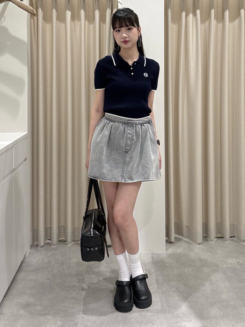 グレー系のスカート、ブルー系のニット/セーターを着用したレディースの春コーディネートの2枚目の写真
