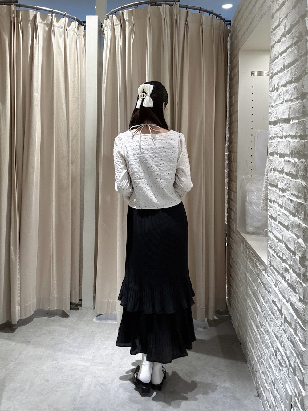 ホワイト系のシャツ/ブラウス、ブラック系のスカートを着用したレディースの春コーディネートの2枚目の写真