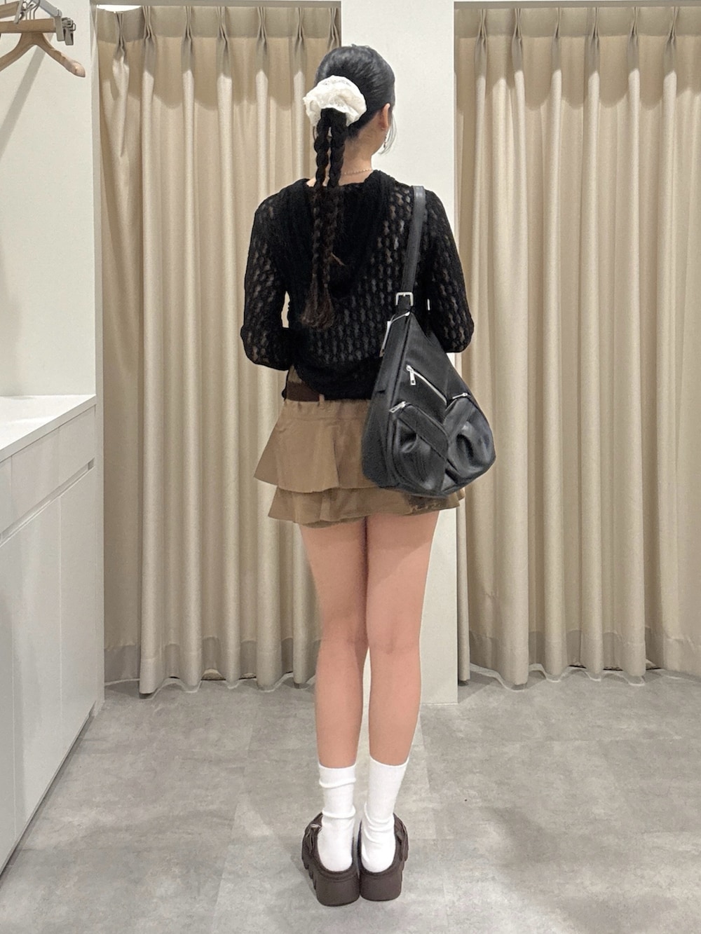 ベージュ系のスカート、ブラック系のTシャツ/カットソーを着用したレディースの春コーディネートの3枚目の写真