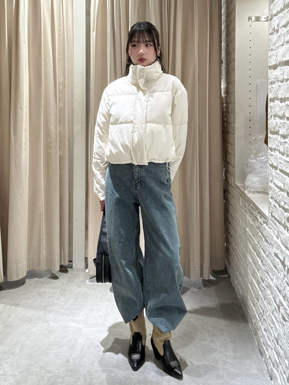 ホワイト系のブルゾン、ブルー系のデニムパンツを着用したレディースの冬コーディネートの2枚目の写真