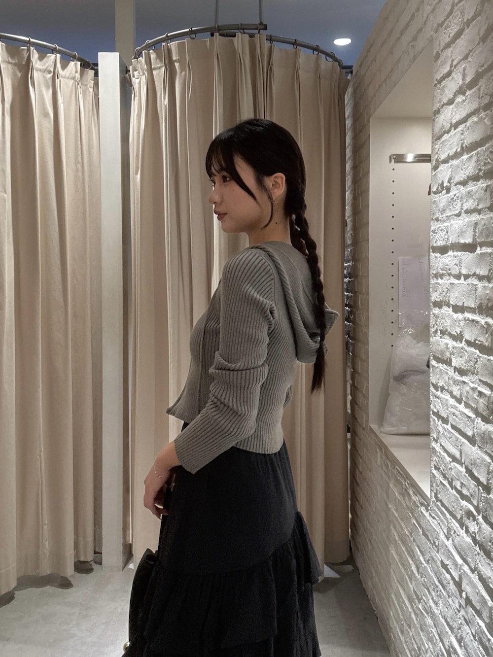 ブラウン系のニット/セーター、ブラック系のスカート、ブラック系のショルダーバッグを着用したレディースの秋コーディネートの2枚目の写真