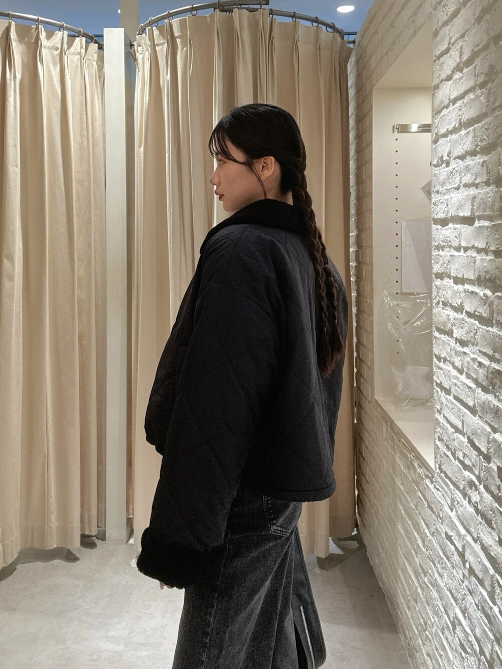 ピンク系のニット/セーター、ブラック系のデニムパンツ、ブラック系のハンドバッグを着用したレディースの秋コーディネートの4枚目の写真