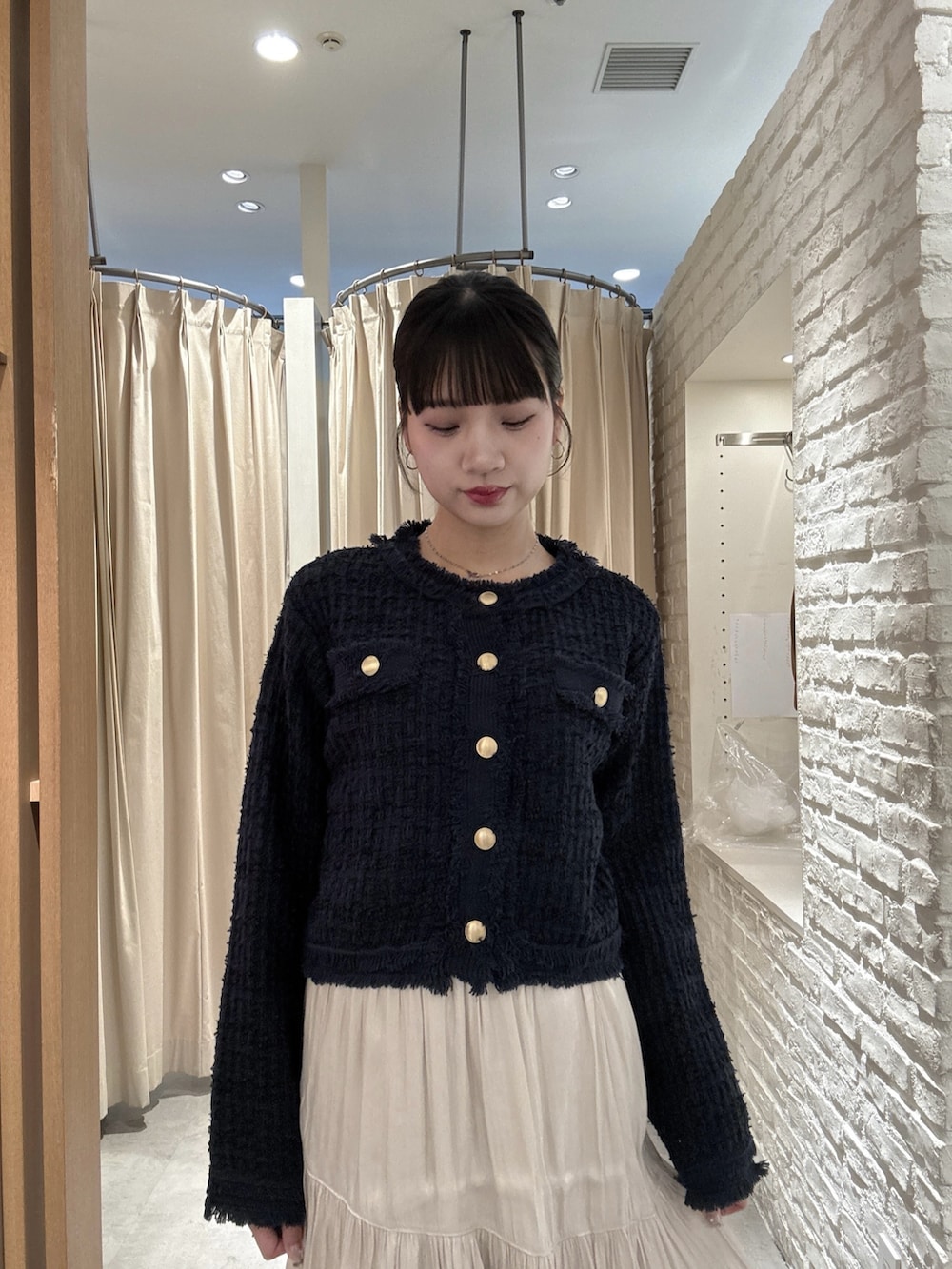 ブルー系のニット/セーター、グレー系のスカートを着用したレディースの春コーディネートの4枚目の写真