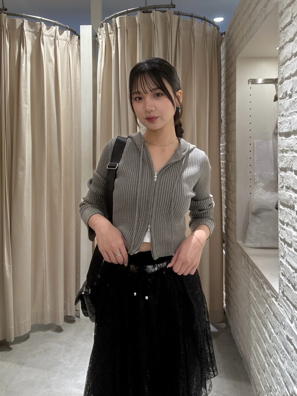 ブラウン系のニット/セーター、ブラック系のスカート、ブラック系のデニムパンツを着用したレディースの秋コーディネートの4枚目の写真