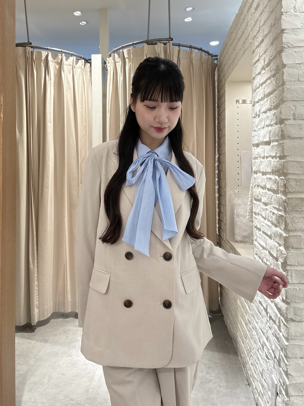 ホワイト系のテーラードジャケット、ホワイト系のその他パンツ、ブルー系のシャツ/ブラウスを着用したレディースの春コーディネートの3枚目の写真