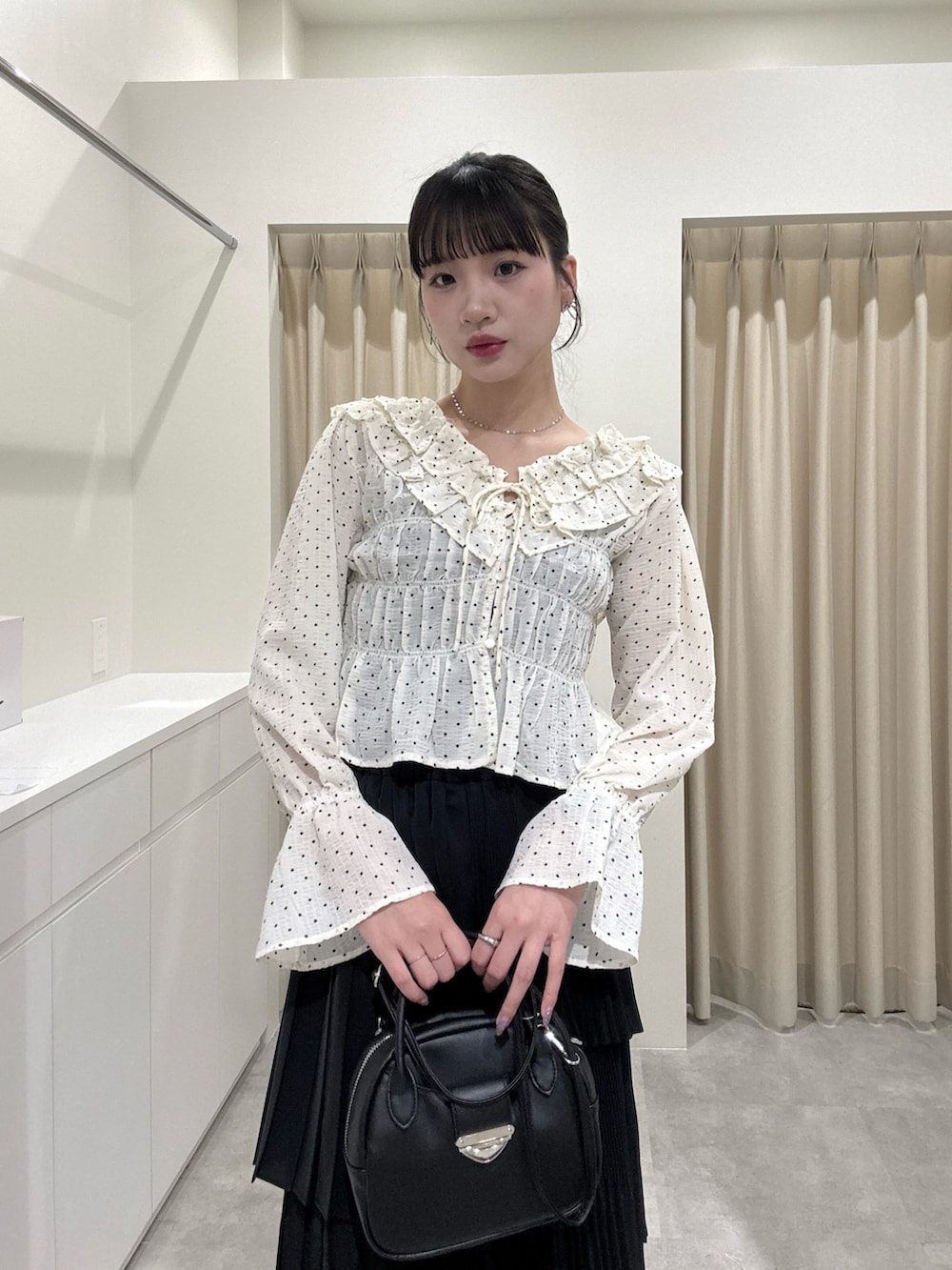 ホワイト系のシャツ/ブラウス、ブラック系のスカートを着用したレディースの春コーディネートの3枚目の写真