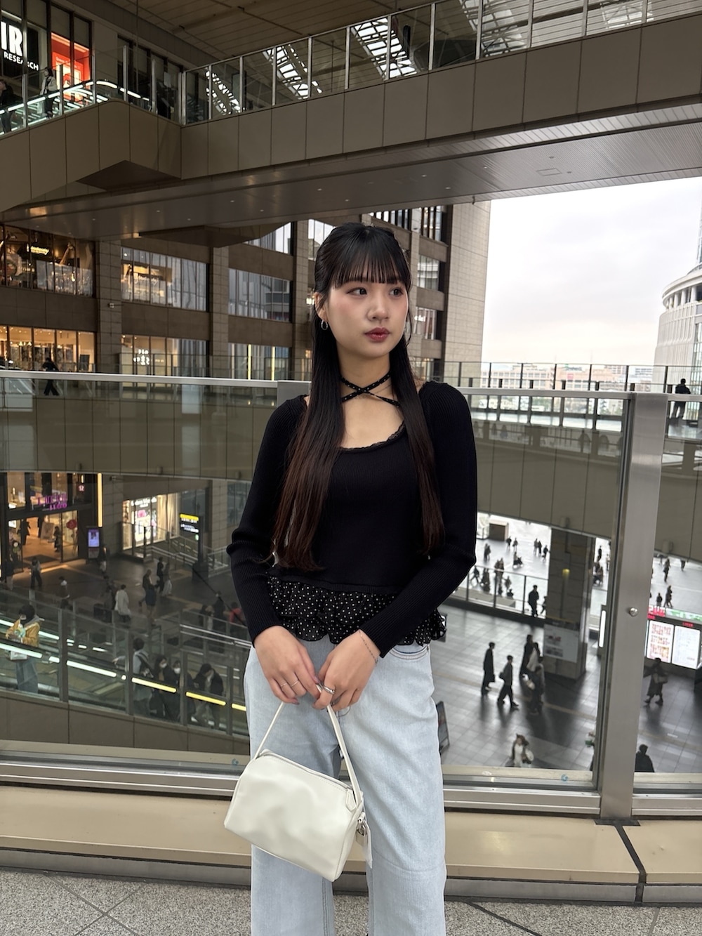 ブラック系のニット/セーター、ブルー系のデニムパンツを着用したレディースの春コーディネートの2枚目の写真