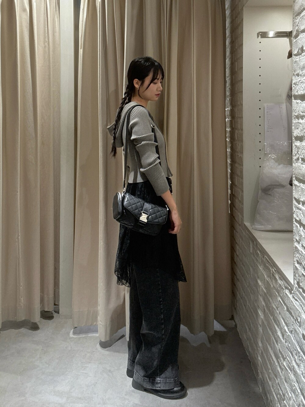 ブラウン系のニット/セーター、ブラック系のスカート、ブラック系のデニムパンツを着用したレディースの秋コーディネートの3枚目の写真