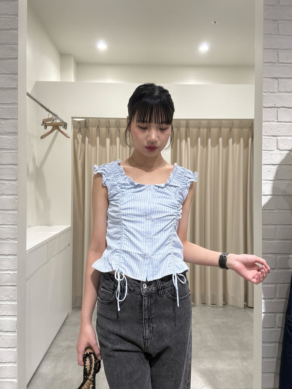 ブルー系のシャツ/ブラウス、ブラック系のデニムパンツを着用したレディースの春コーディネートの4枚目の写真