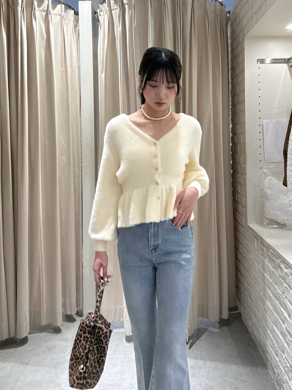 ホワイト系のニット/セーター、ブルー系のデニムパンツを着用したレディースの冬コーディネートの3枚目の写真