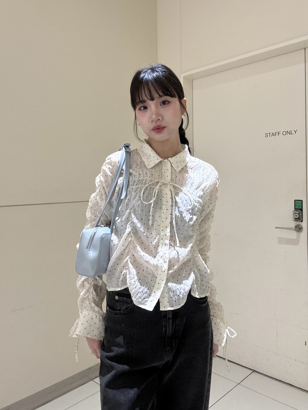 ホワイト系のシャツ/ブラウス、ブラック系のデニムパンツを着用したレディースの春コーディネートの3枚目の写真