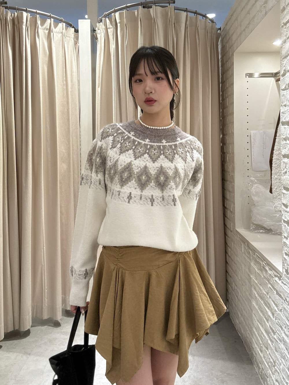 ホワイト系のニット/セーター、ベージュ系のスカートを着用したレディースの冬コーディネートの3枚目の写真