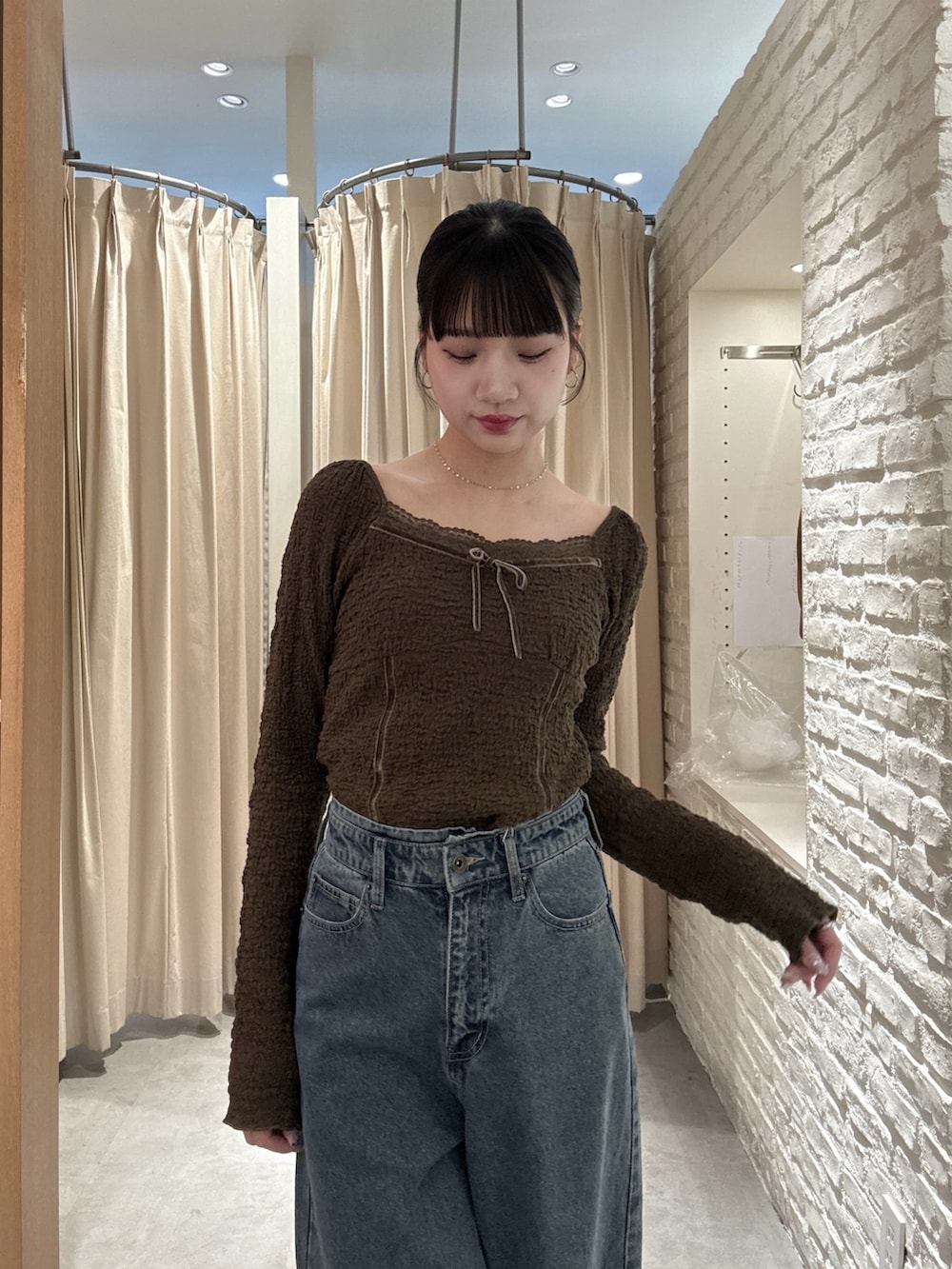 ブラウン系のTシャツ/カットソー、ブルー系のデニムパンツを着用したレディースの春コーディネートの3枚目の写真