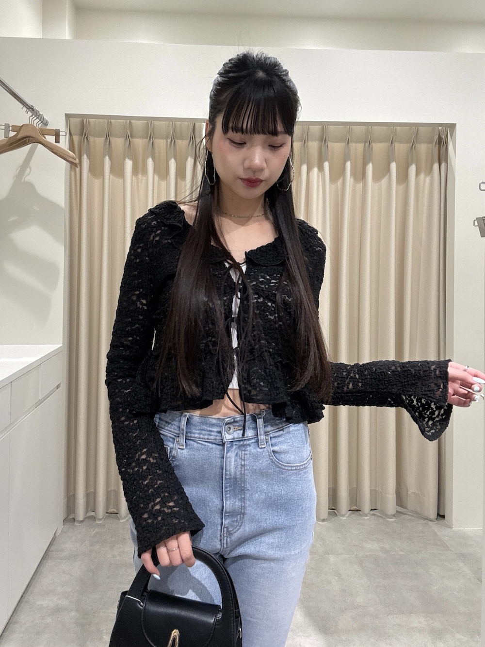 ブラック系のシャツ/ブラウス、ブルー系のデニムパンツを着用したレディースの春コーディネートの3枚目の写真