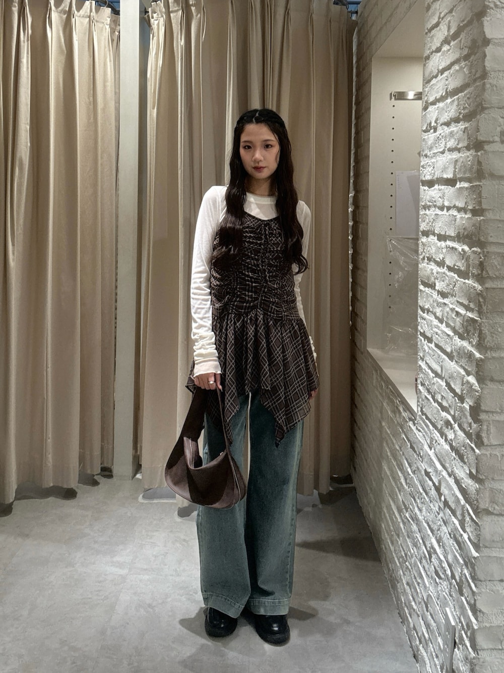 ブラウン系のワンピース、ホワイト系のTシャツ/カットソー、ブルー系のデニムパンツを着用したレディースの秋コーディネートの2枚目の写真