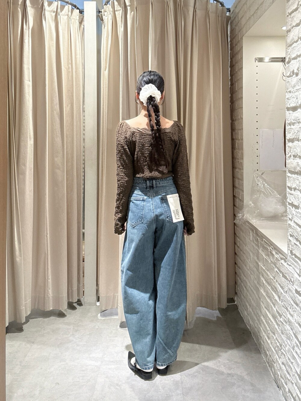 ブラウン系のTシャツ/カットソー、ブルー系のデニムパンツを着用したレディースの春コーディネートの2枚目の写真