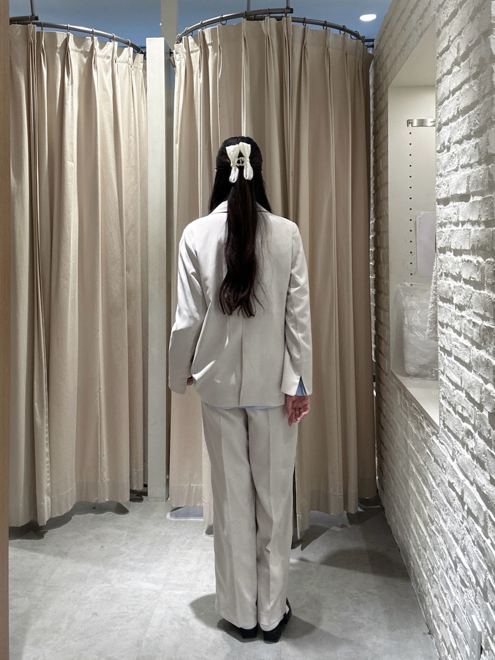 ホワイト系のテーラードジャケット、ホワイト系のその他パンツ、ブルー系のシャツ/ブラウスを着用したレディースの春コーディネートの2枚目の写真