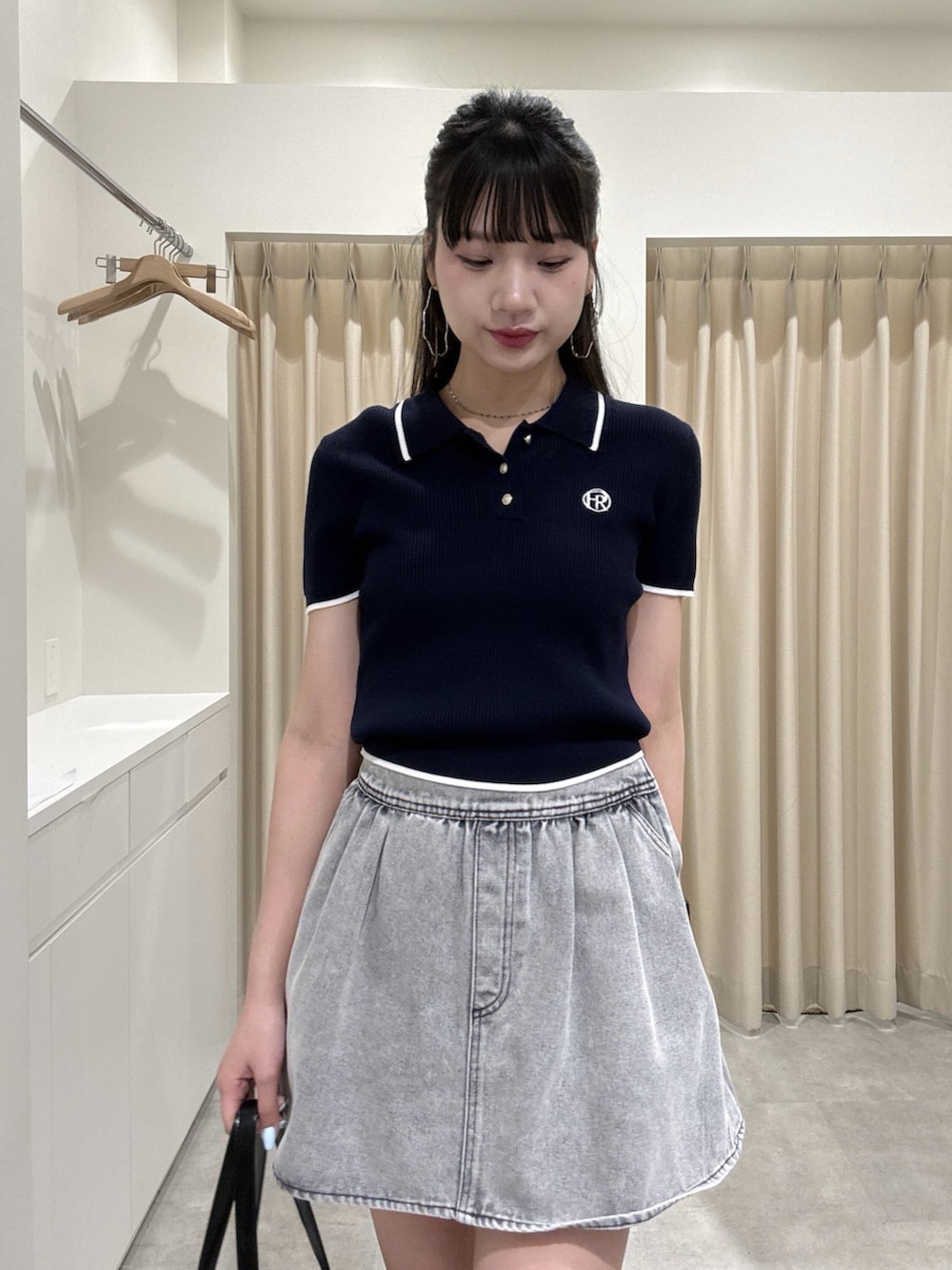 グレー系のスカート、ブルー系のニット/セーターを着用したレディースの春コーディネートの3枚目の写真
