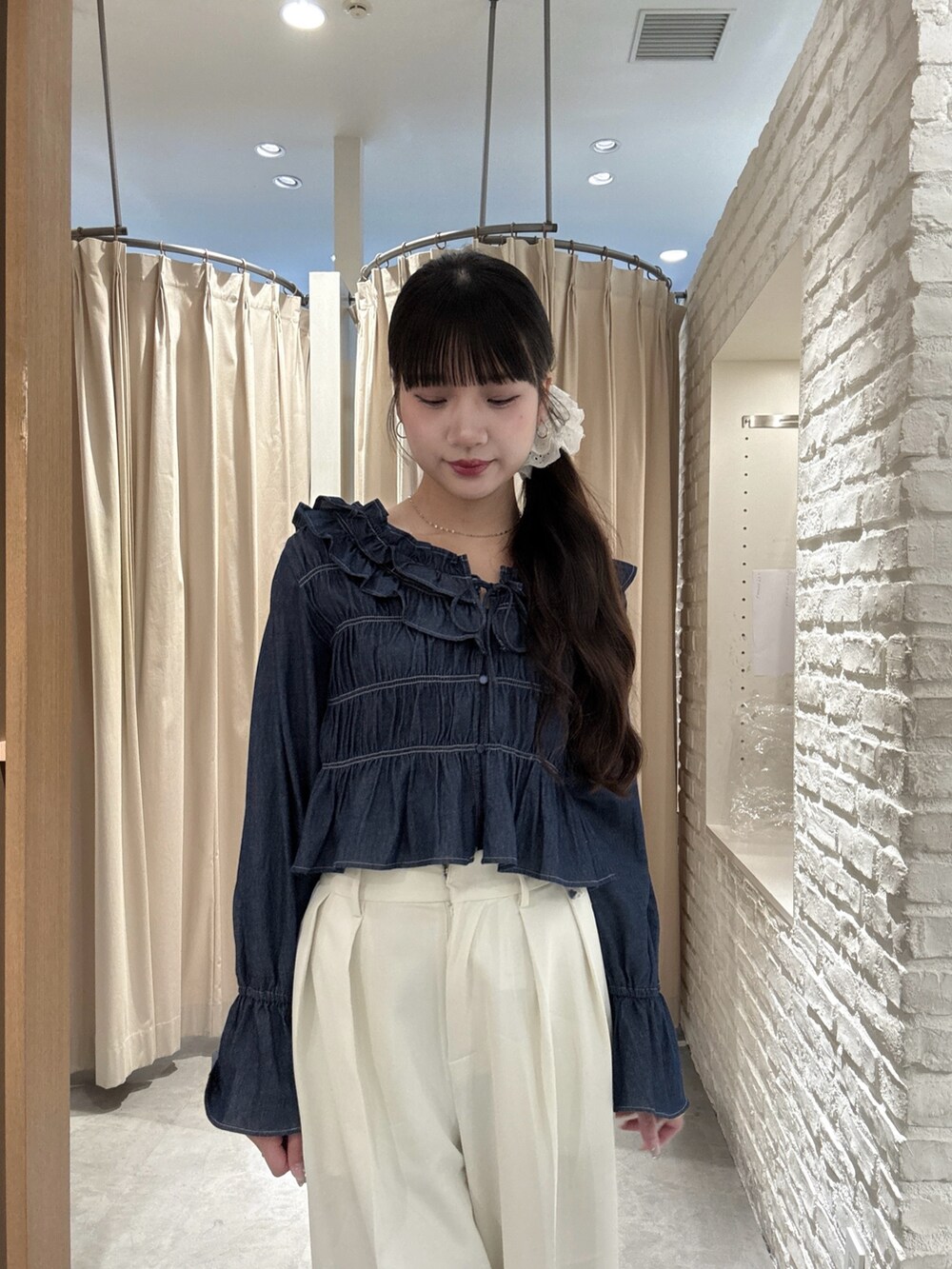 ホワイト系のスラックス、ブルー系のシャツ/ブラウスを着用したレディースの春コーディネートの4枚目の写真