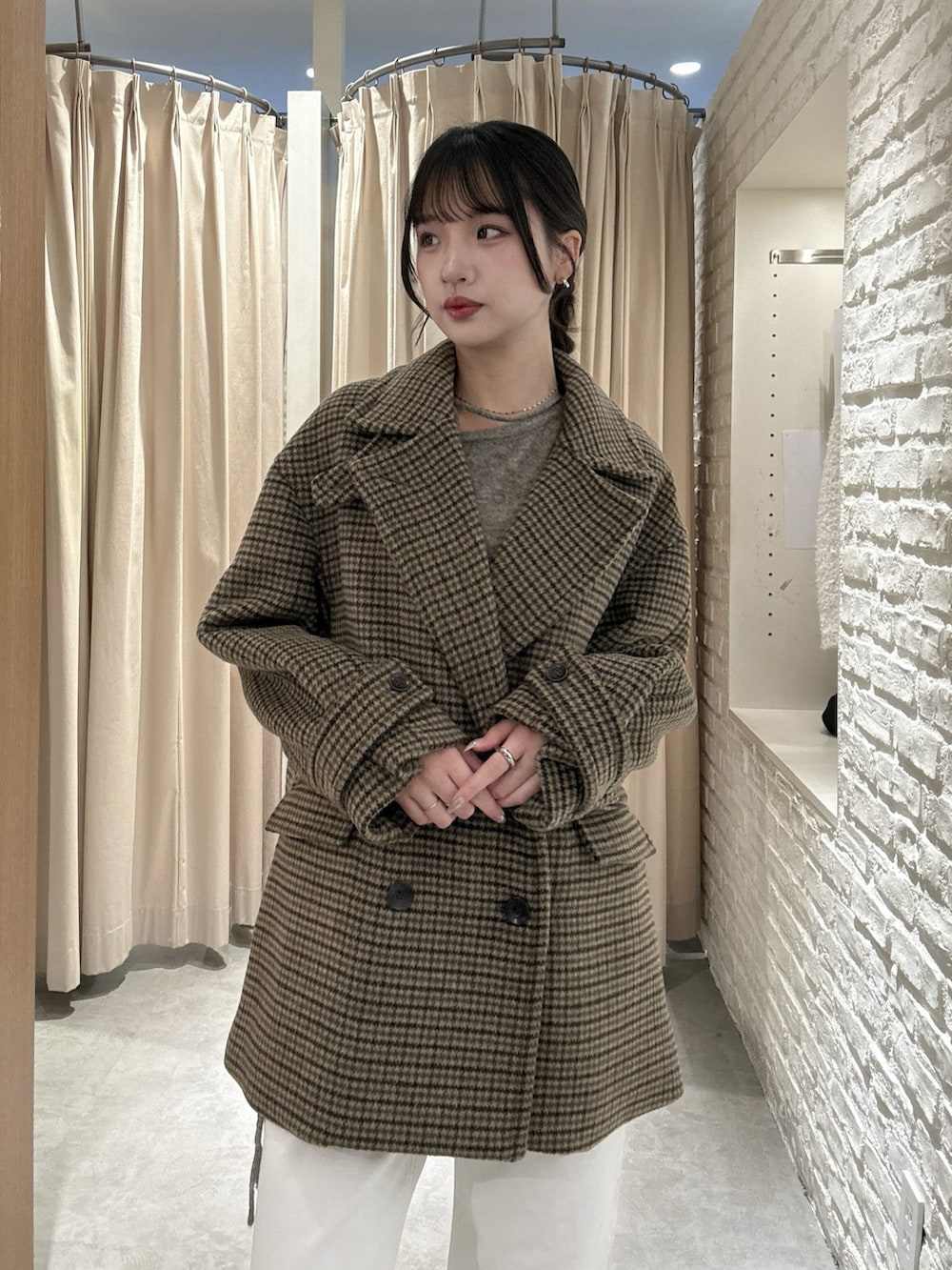 ベージュ系のピーコート、ホワイト系のデニムパンツ、ブラウン系のニット/セーターを着用したレディースの冬コーディネートの3枚目の写真