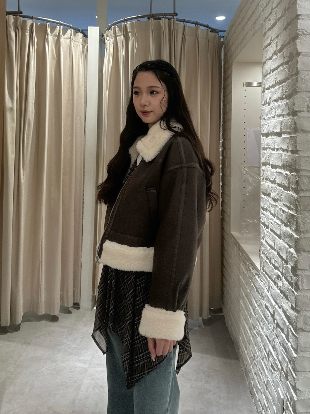 ブラウン系のブルゾン、ブラウン系のワンピース、ホワイト系のTシャツ/カットソーを着用したレディースの秋コーディネートの3枚目の写真