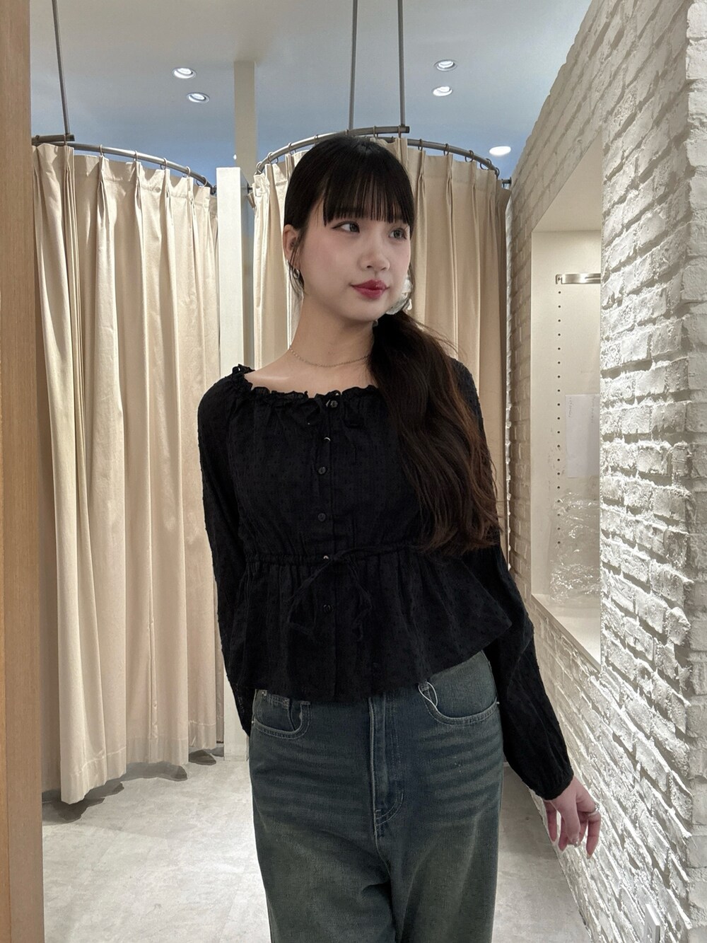 ブルー系のデニムパンツ、ブラック系のシャツ/ブラウスを着用したレディースの春コーディネートの3枚目の写真