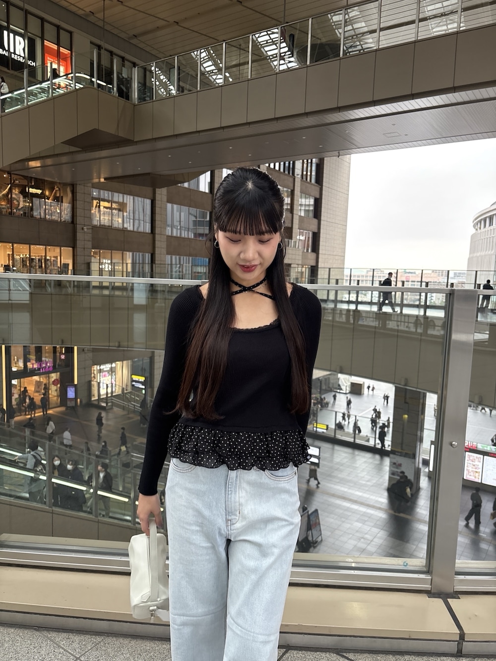 ブラック系のニット/セーター、ブルー系のデニムパンツを着用したレディースの春コーディネートの3枚目の写真