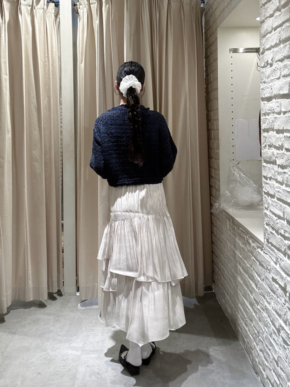 ブルー系のニット/セーター、グレー系のスカートを着用したレディースの春コーディネートの3枚目の写真