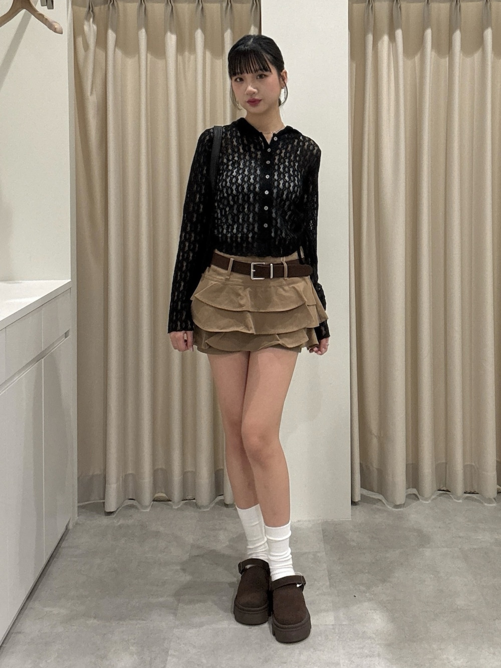 ベージュ系のスカート、ブラック系のTシャツ/カットソーを着用したレディースの春コーディネートの2枚目の写真