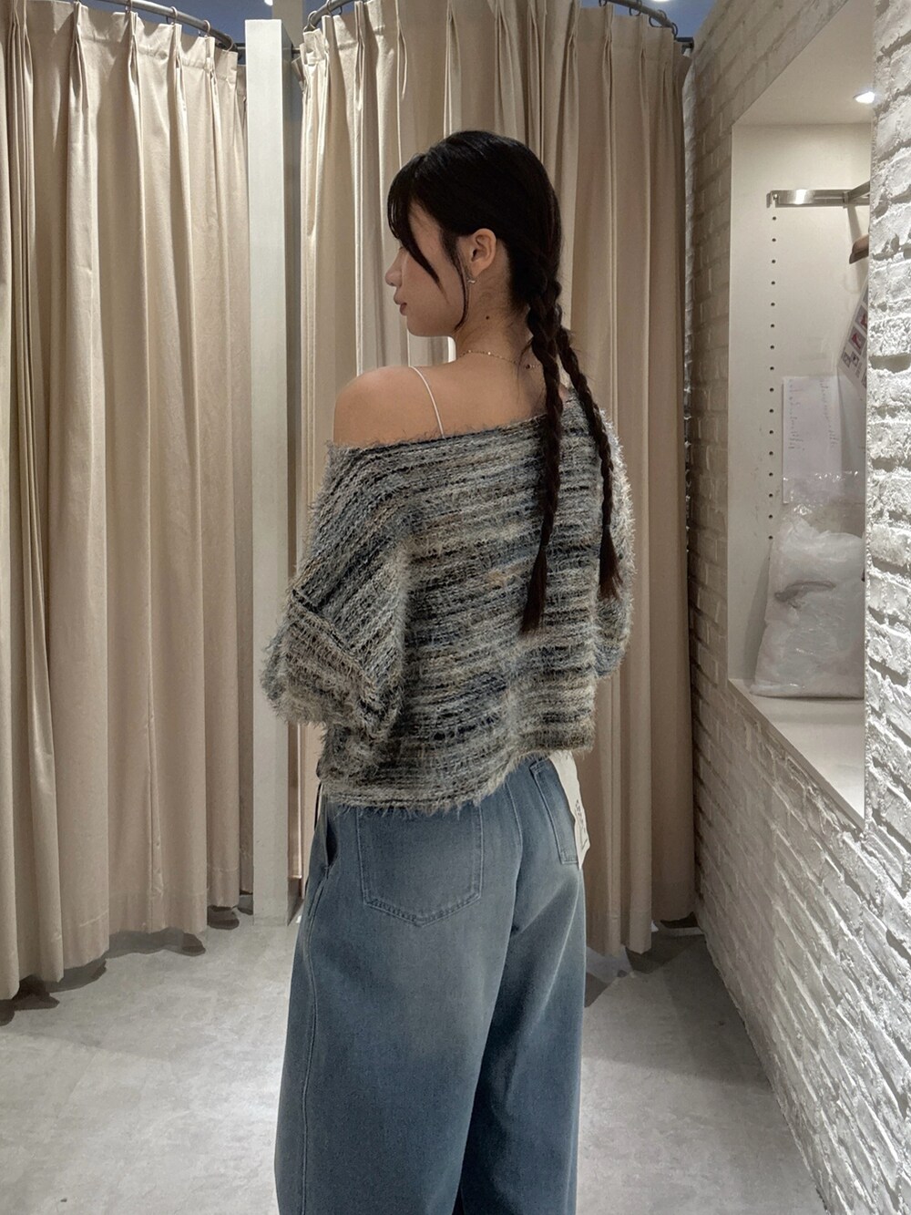 グリーン系のニット/セーター、ブラック系のショルダーバッグを着用したレディースの秋コーディネートの4枚目の写真