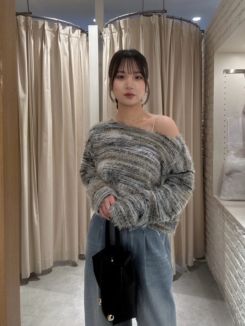 グリーン系のニット/セーター、ブラック系のショルダーバッグを着用したレディースの秋コーディネートの3枚目の写真