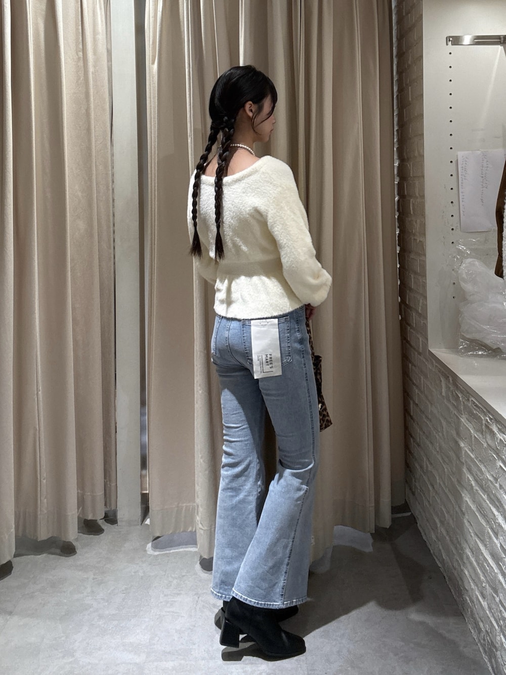 ホワイト系のニット/セーター、ブルー系のデニムパンツを着用したレディースの冬コーディネートの2枚目の写真