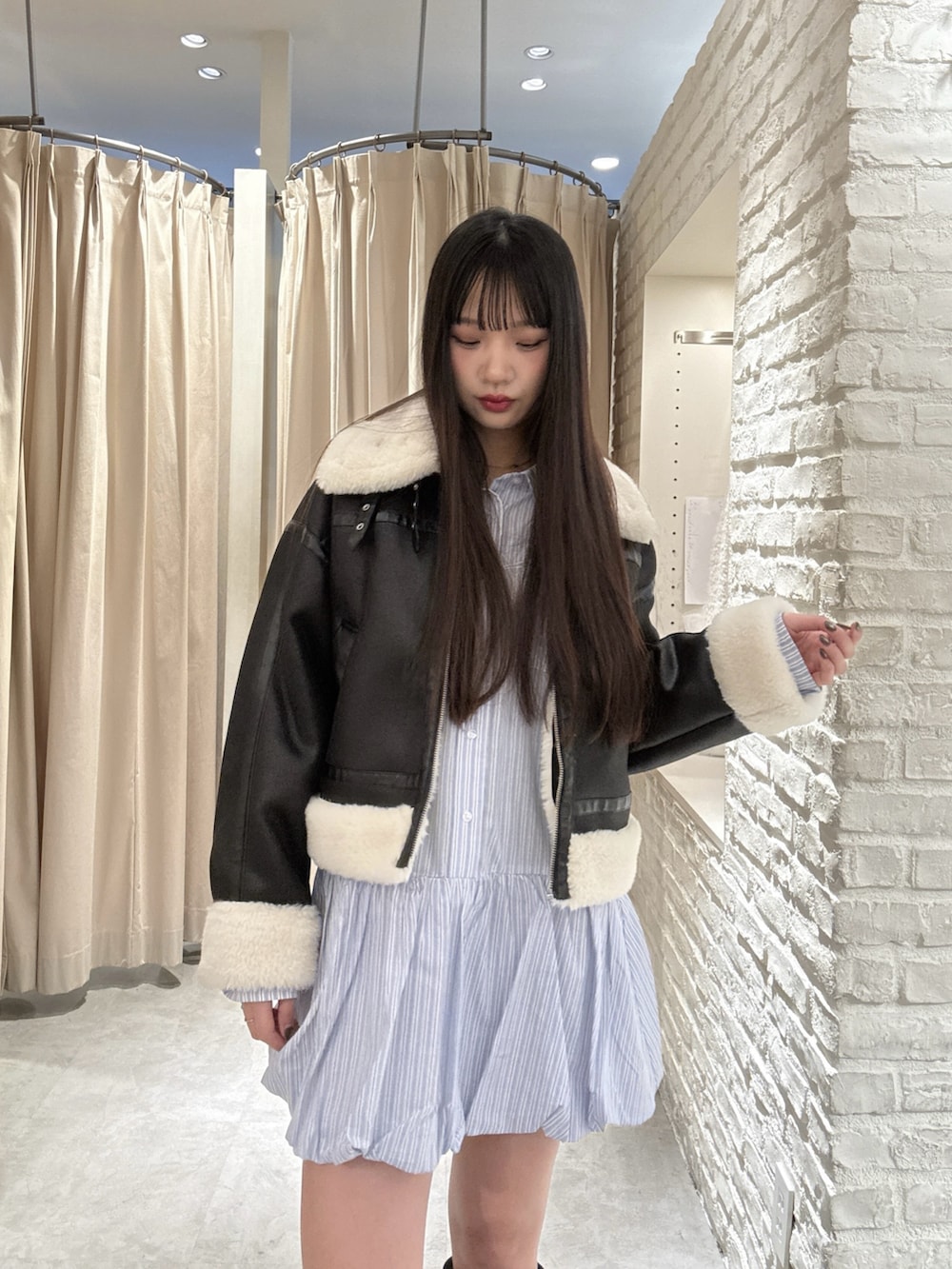 ブルー系のワンピース、ブラック系のブルゾンを着用したレディースの冬コーディネートの2枚目の写真