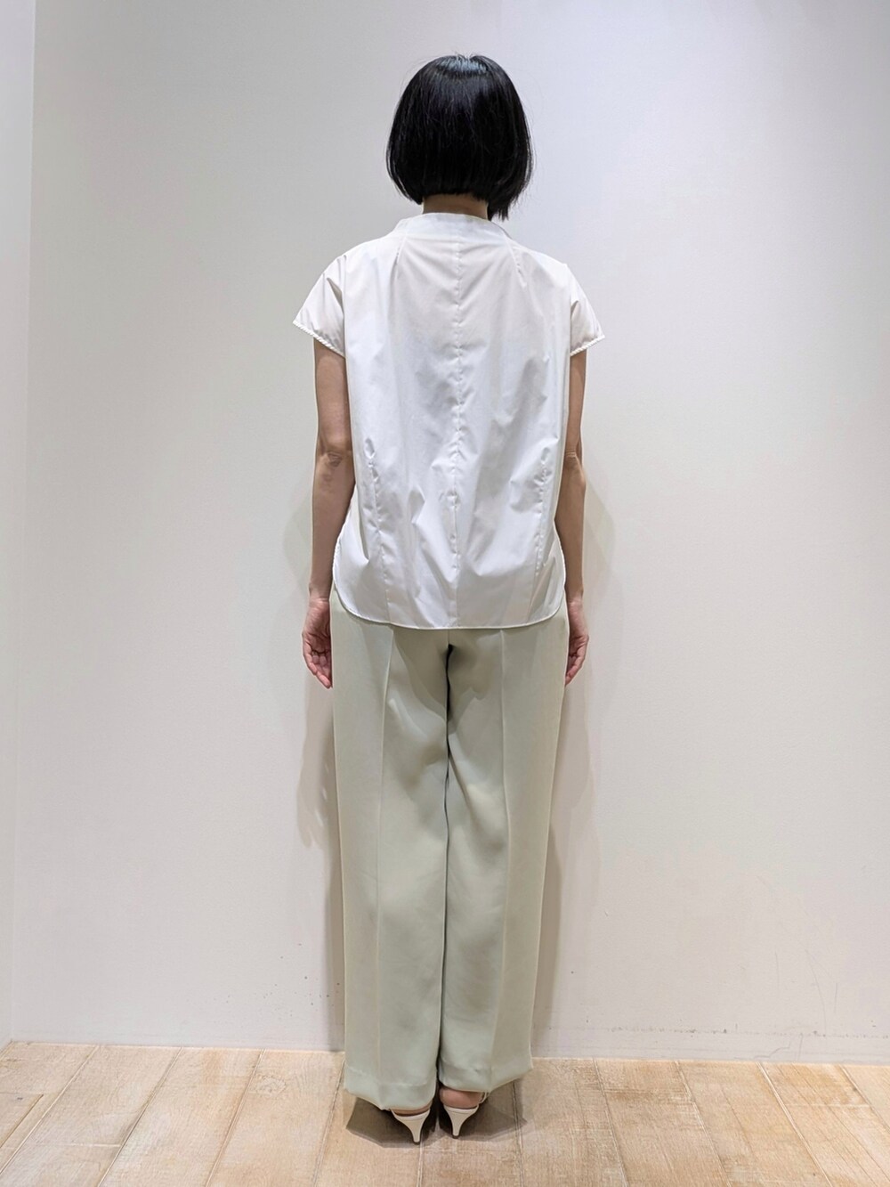 グリーン系のスラックス、ホワイト系のシャツ/ブラウスを着用したレディースの夏コーディネートの4枚目の写真