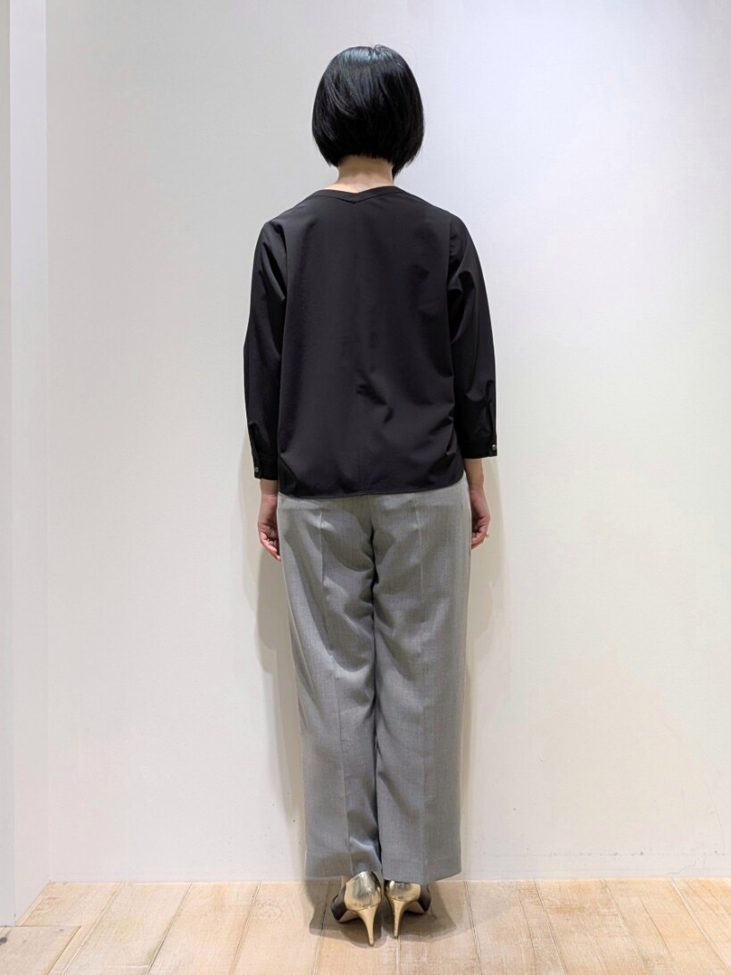 ブラック系のシャツ/ブラウス、グレー系のスラックスを着用したレディースの春コーディネートの3枚目の写真